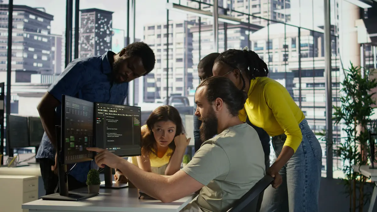 Startup team reviewing a custom software architecture diagram beside a wall of disconnected SaaS tool logos, weighing build versus buy